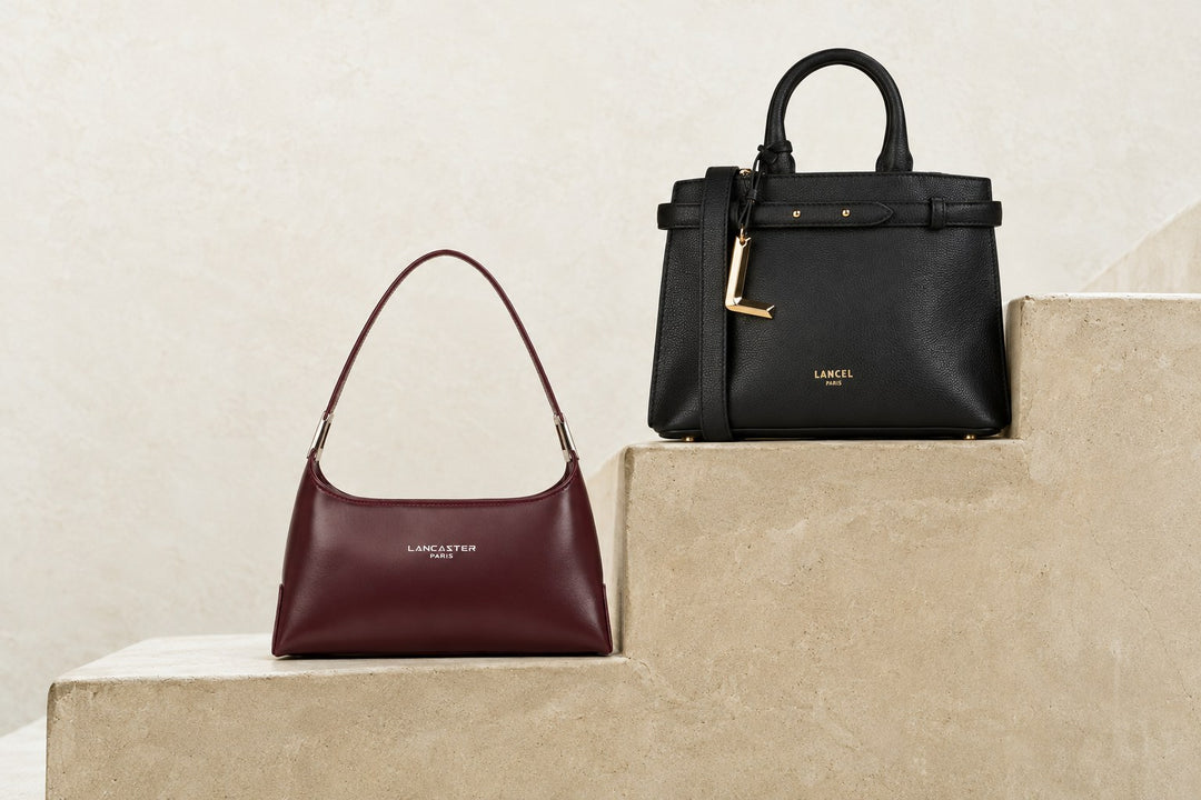 Sac Lancaster Suave Ace bordeaux et sac Lancel Faubourg noir posés sur un escalier en pierre claire