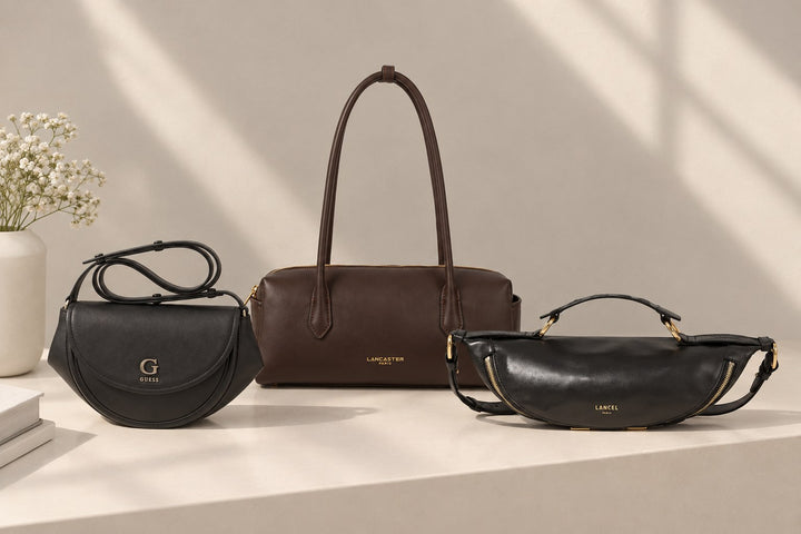 Sacs bandoulière Guess noir, Lancaster Donna Cube marron et Lancel noir sur un socle blanc au soleil