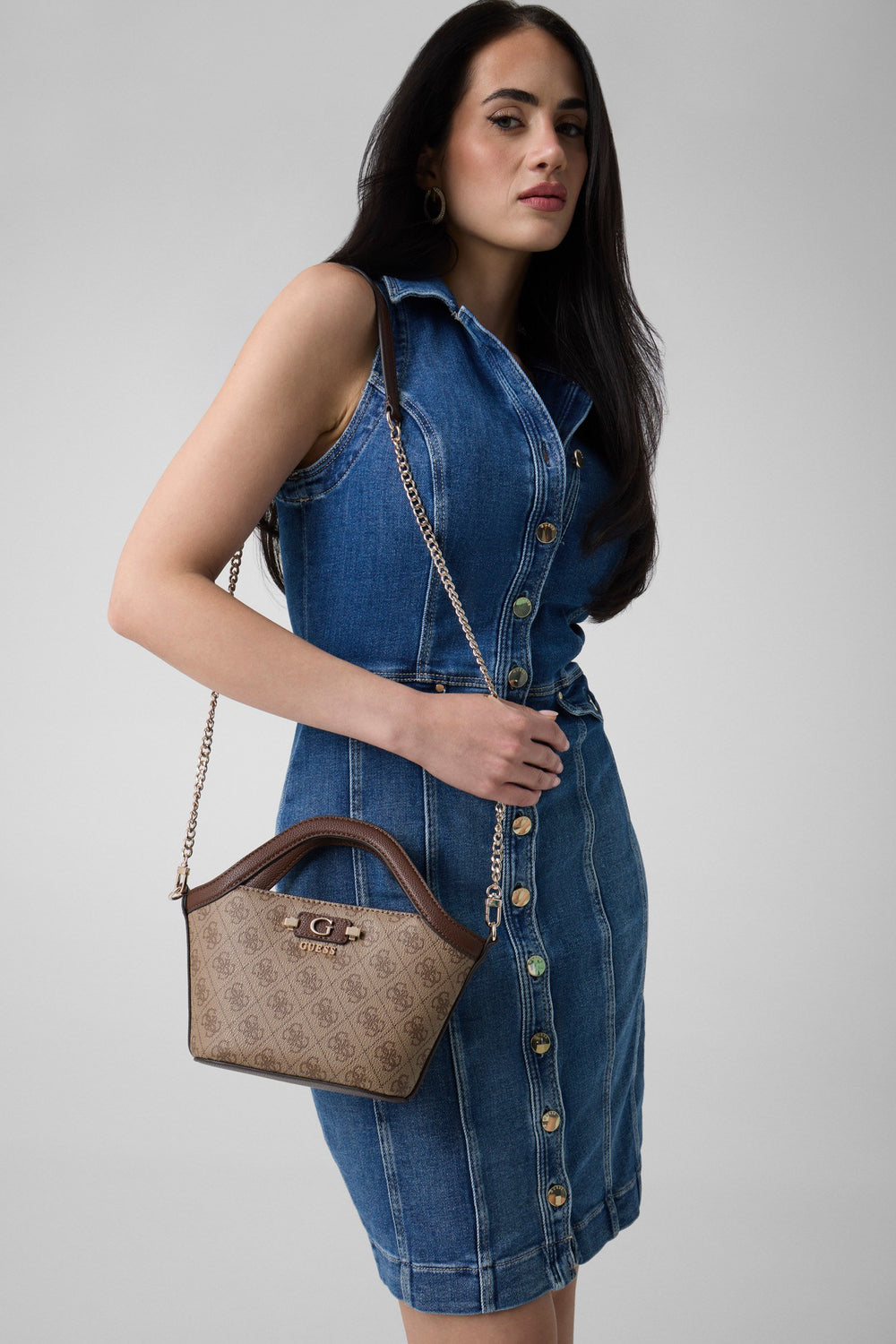 Borsa tote Guess Lindsey Mini beige, portata a tracolla con un abito chemisier in denim blu.