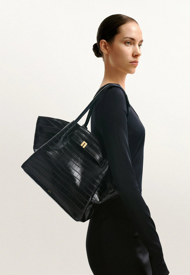 Cabas JW PEI Hana Black Croc porté à l'épaule par une femme, vue de profil gauche