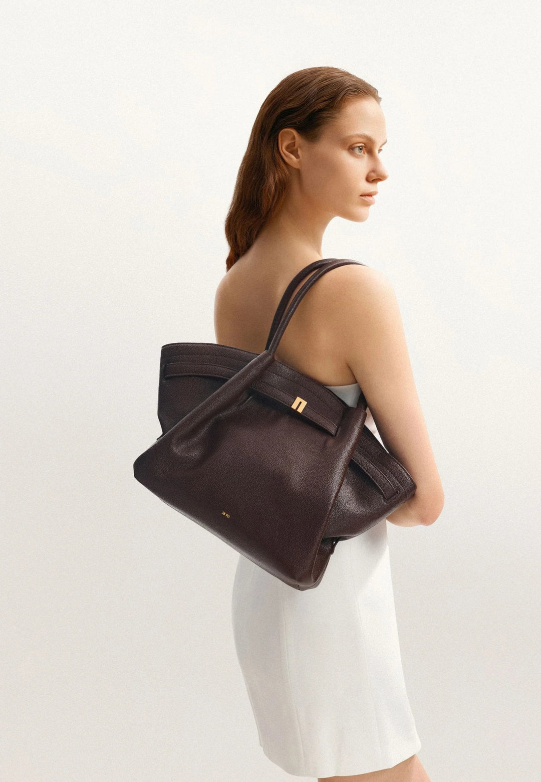 Cabas JW PEI Hana Dark Brown porté à l'épaule par une femme, vue de dos