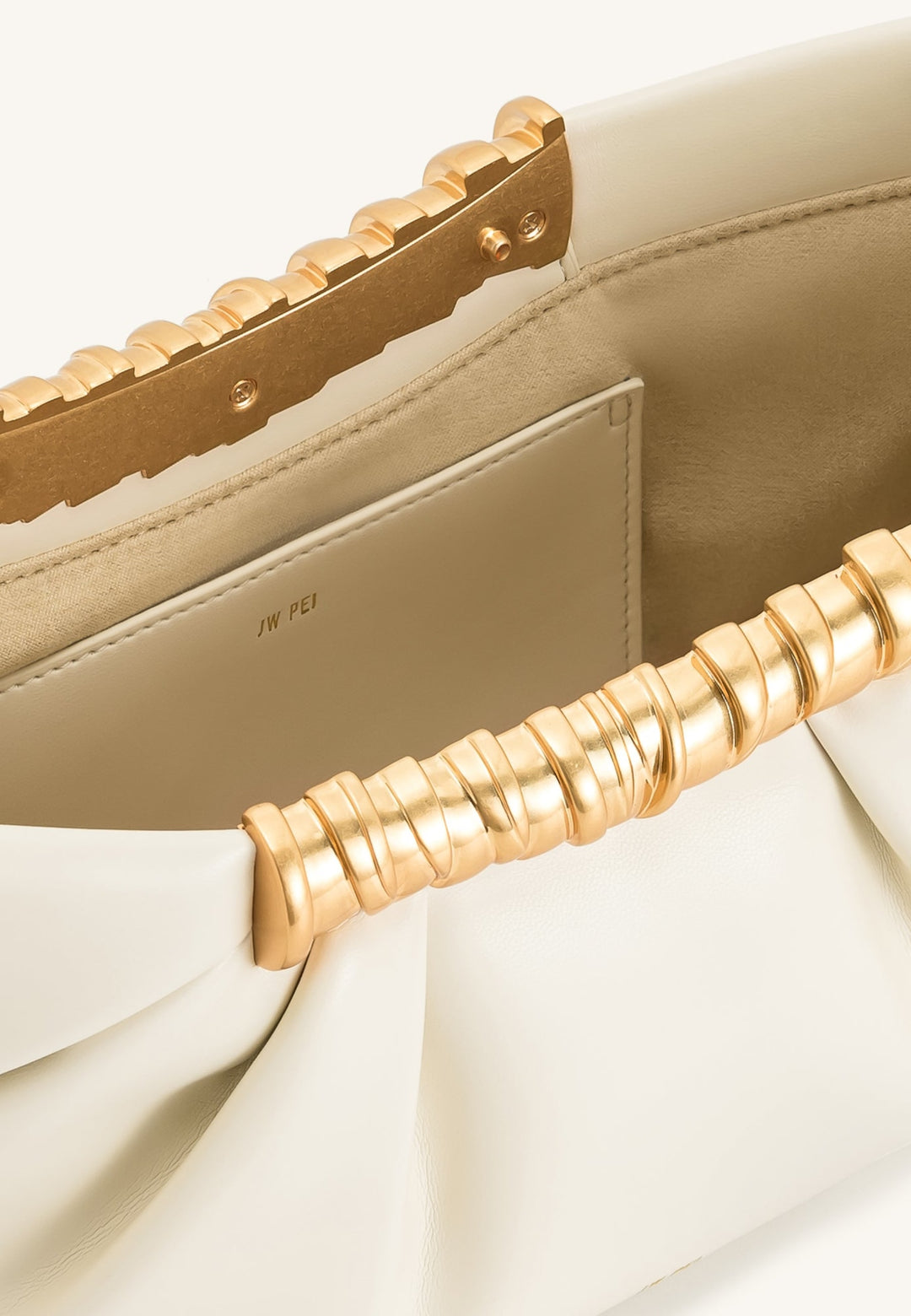 Intérieur de la pochette JW PEI Leia blanche avec logo JW PEI et détails dorés