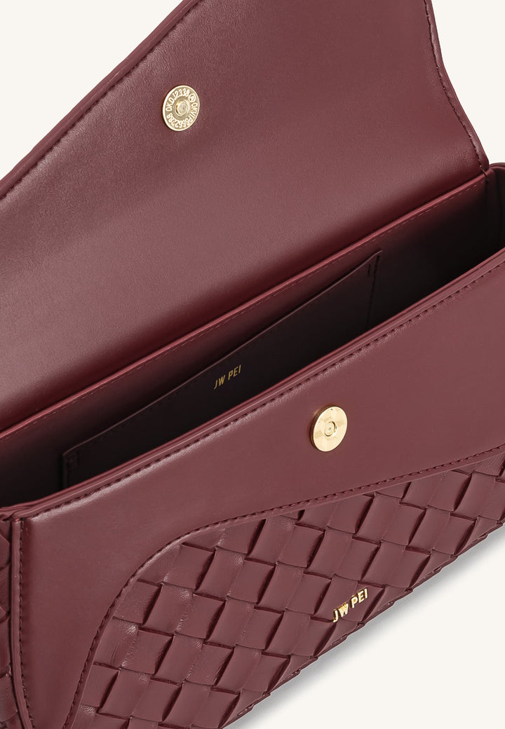 Intérieur d'un sac bandoulière JW PEI Addisyn burgundy avec logo doré et fermoir magnétique
