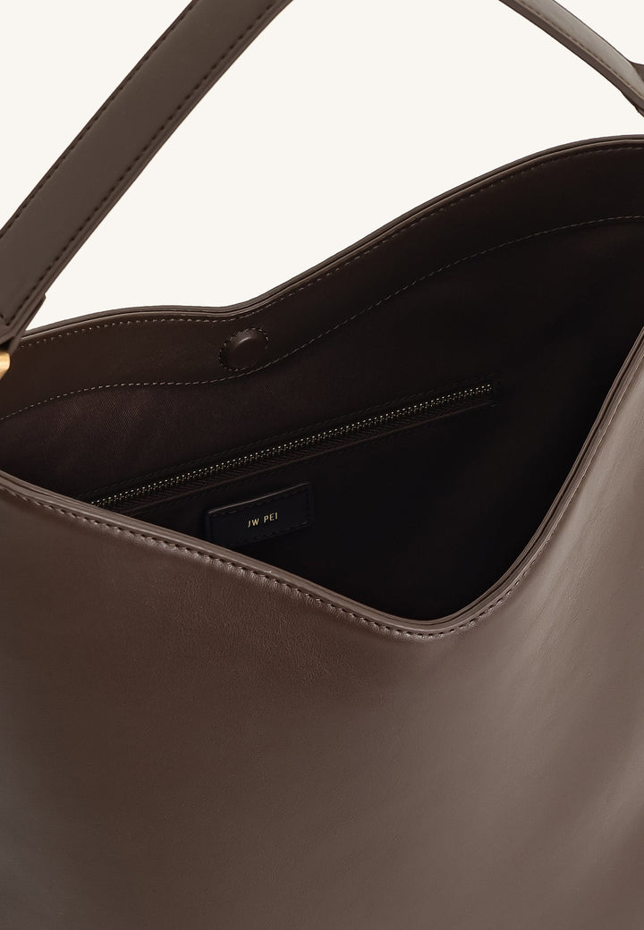 Intérieur du sac bandoulière JW PEI Aria marron foncé, avec poche zippée et logo JW PEI doré