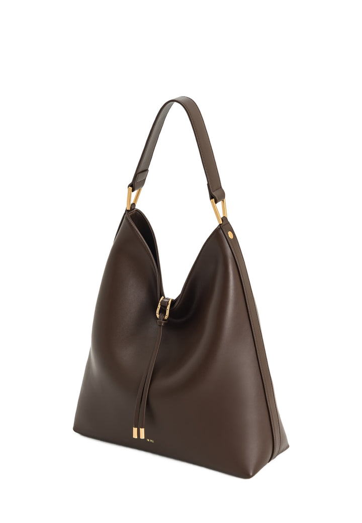 Sac bandoulière JW PEI Aria Dark Brown en simili cuir, porté à l'épaule, avec détails dorés.