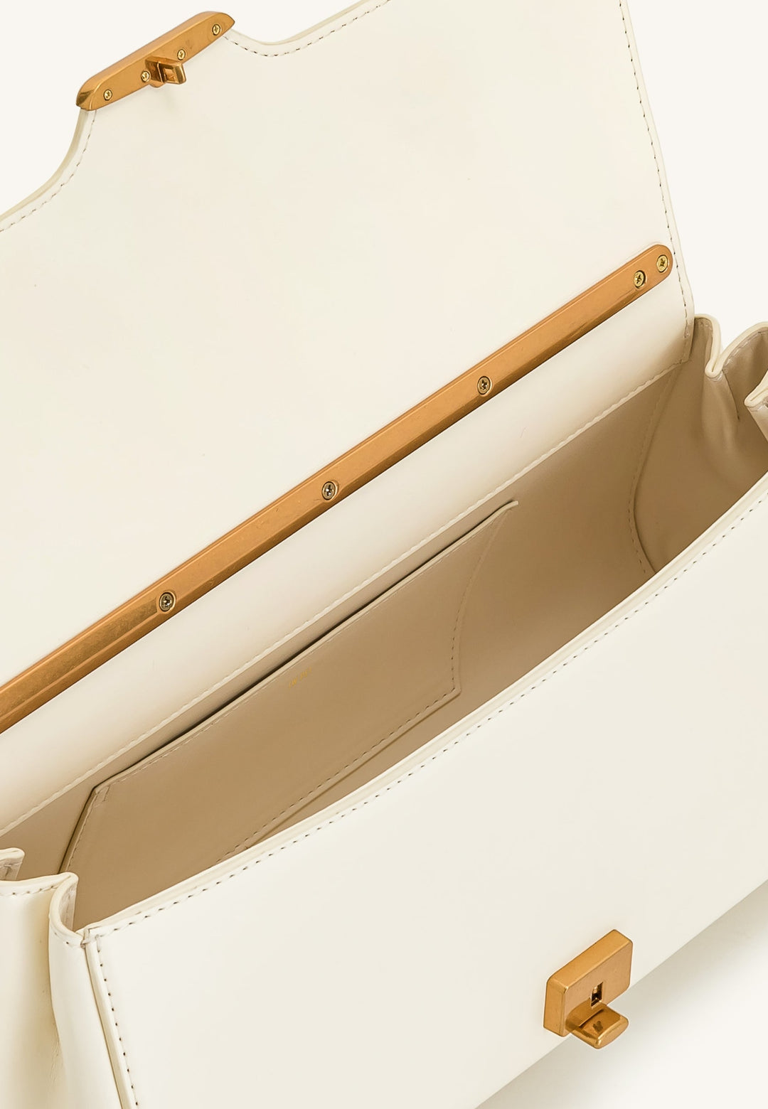 Intérieur d'un sac bandoulière JW PEI Eloise blanc, avec une poche intérieure et une fermeture dorée.