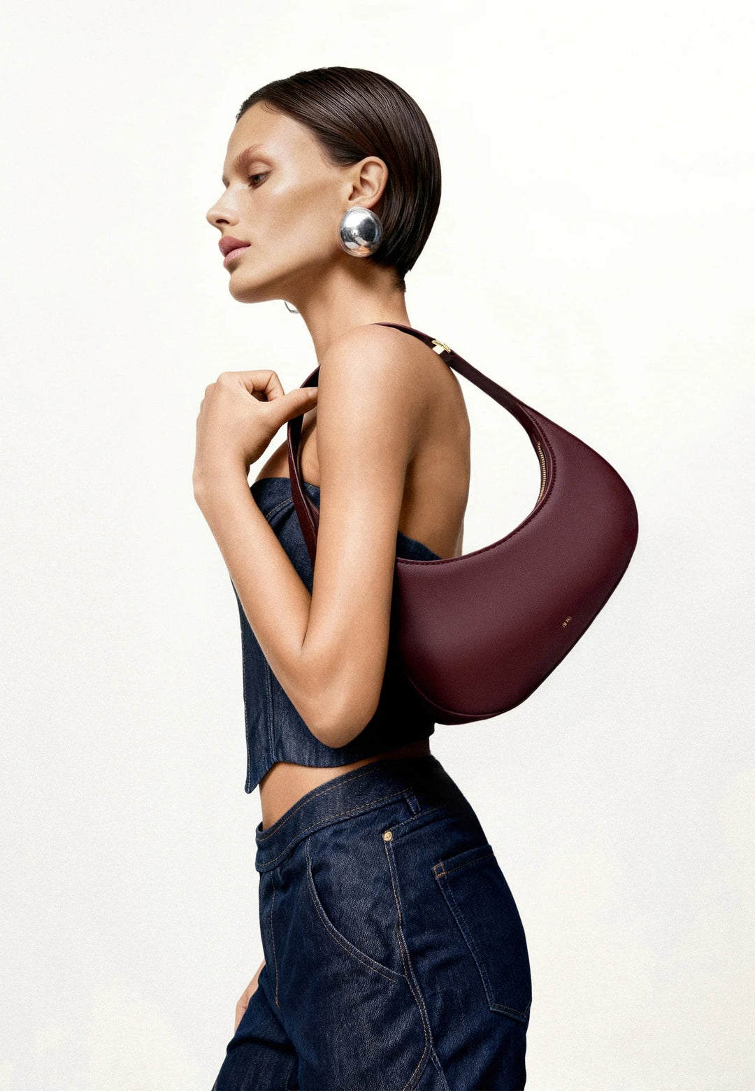 Sac bandoulière JW PEI Harlee Claret porté à l'épaule, vue de profil, simili cuir