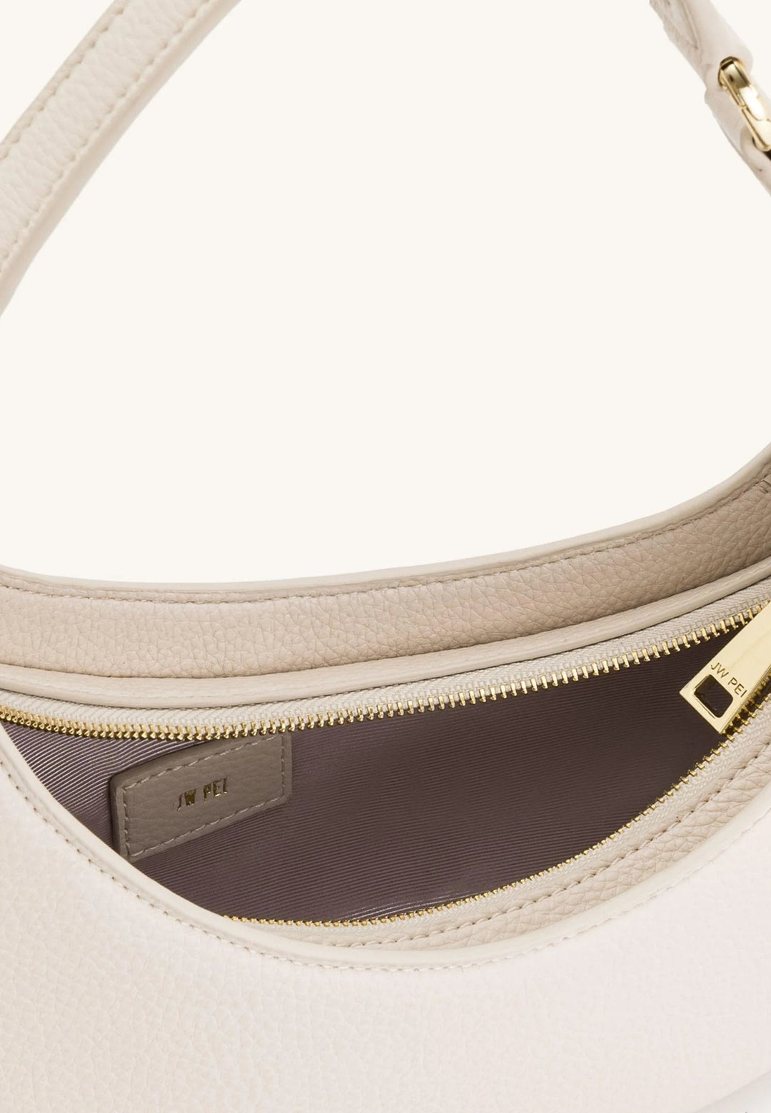 Intérieur d'un sac bandoulière JW PEI Harlee Ivory avec fermeture éclair dorée et étiquette de marque