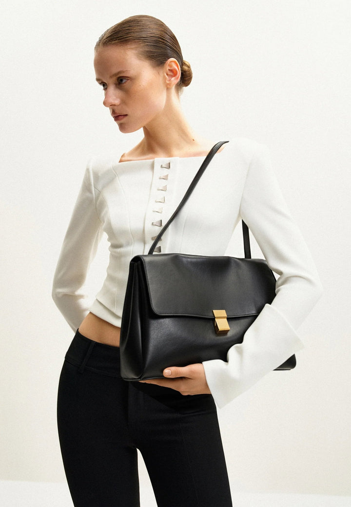 Sac bandoulière JW PEI Hilary noir en simili cuir, porté en travers du corps, avec une boucle dorée sur le rabat.