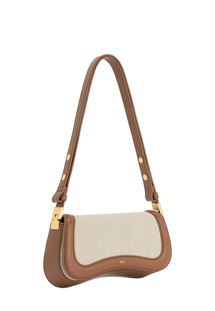 Sac bandoulière JW PEI Joy en toile marron avec détails en cuir marron et fermoir doré, porté à l'épaule.