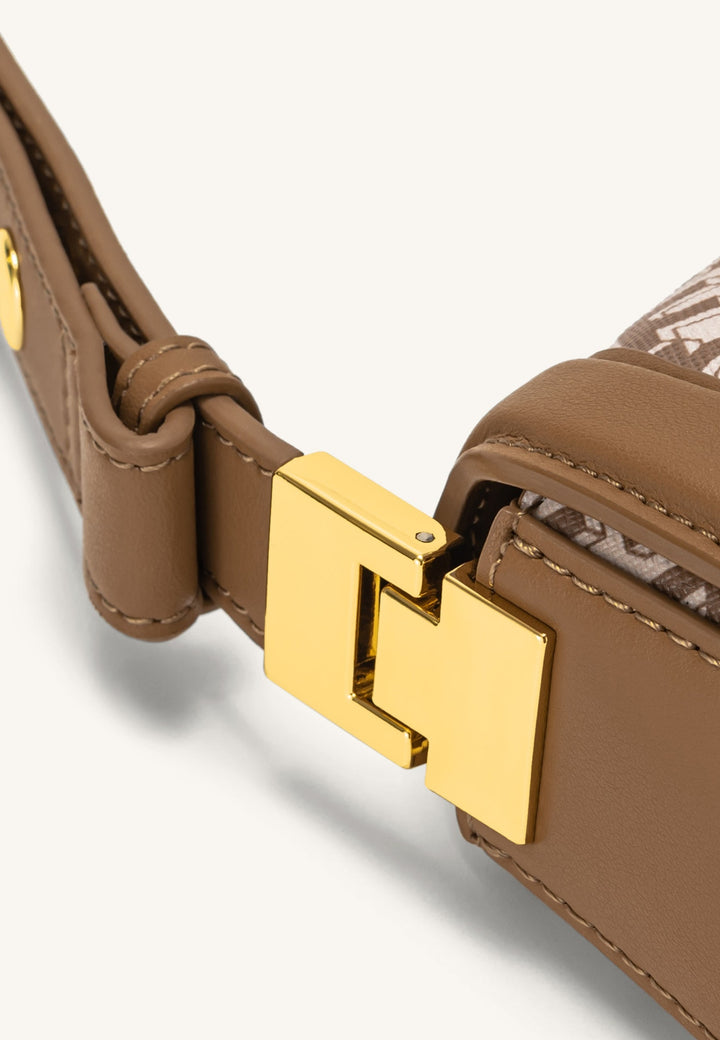 Gros plan sur le fermoir métallique doré d'un sac bandoulière JW PEI Joy marron.