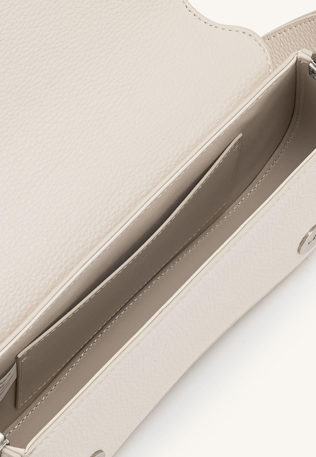 Intérieur d'un sac bandoulière JW PEI Joy French Oak en simili cuir, avec compartiments et étiquette