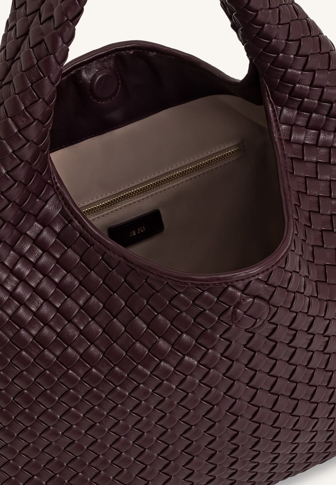 Intérieur du sac bandoulière JW PEI Laura Deep Burgundy avec fermeture éclair dorée et logo de la marque