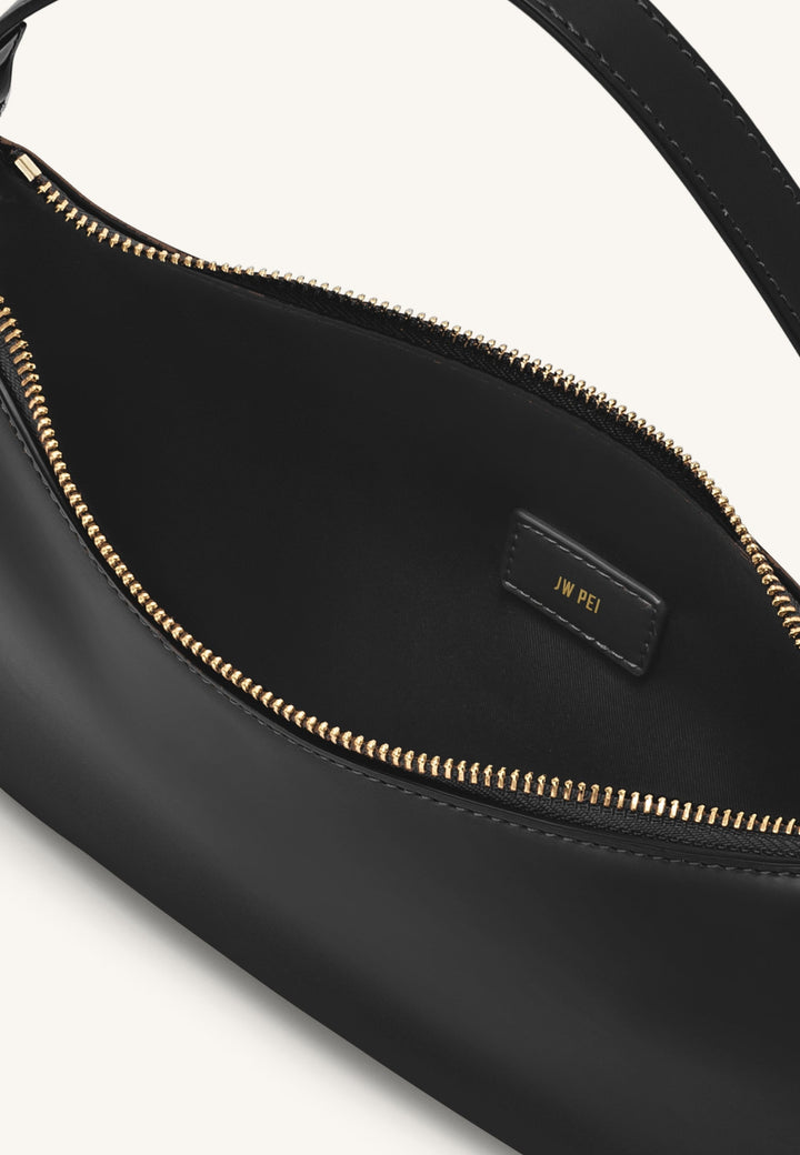 Intérieur du sac bandoulière JW PEI Lily noir avec logo doré "JW PEI" sur une étiquette en cuir