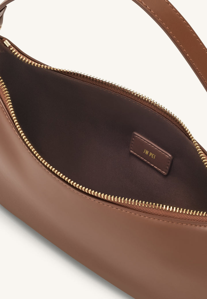 Intérieur du sac bandoulière JW PEI Lily marron avec étiquette de marque dorée et fermeture éclair dorée