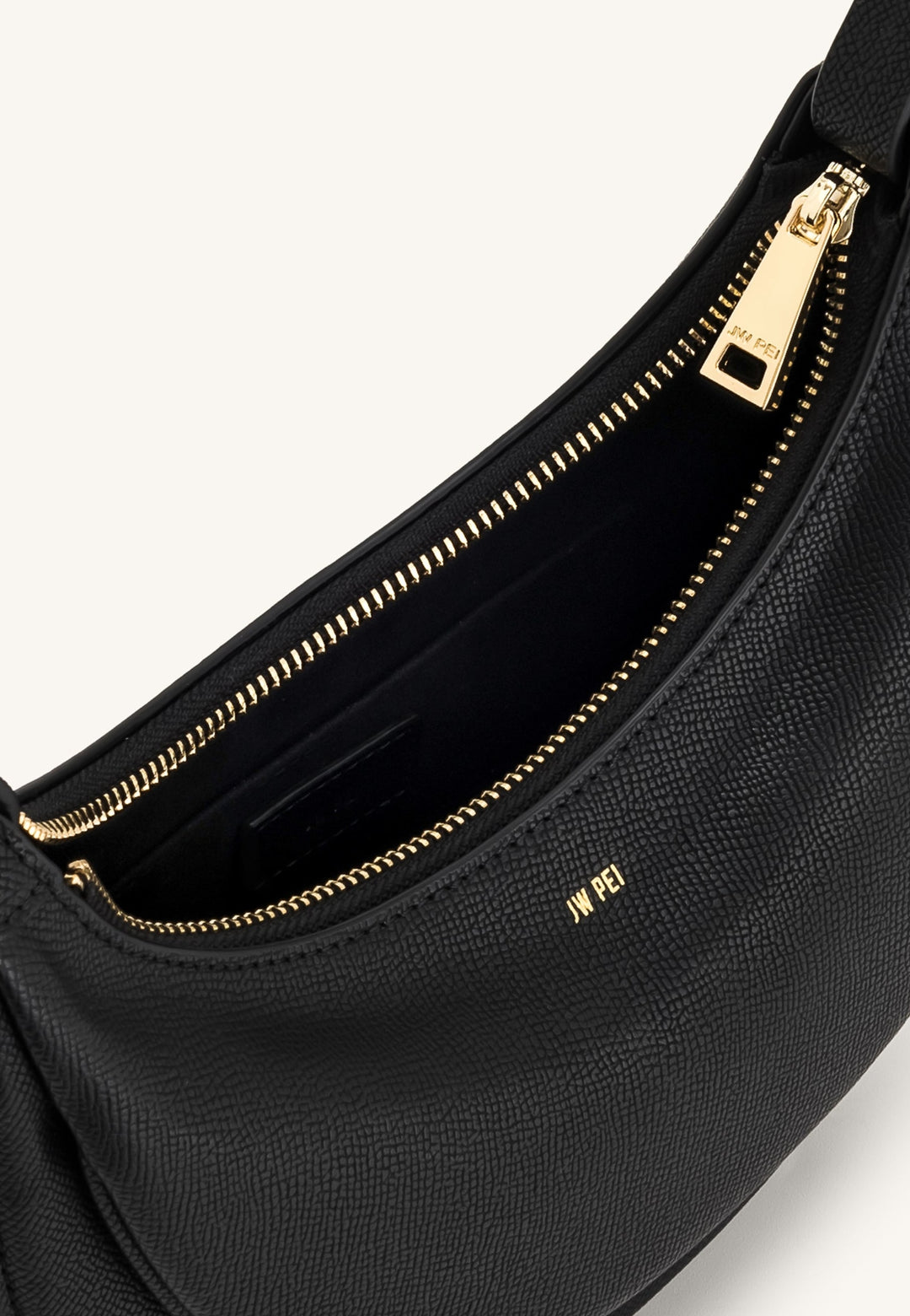Sac bandoulière JW PEI Sharon noir, détail de la fermeture éclair dorée et du logo JW PEI à l'intérieur.