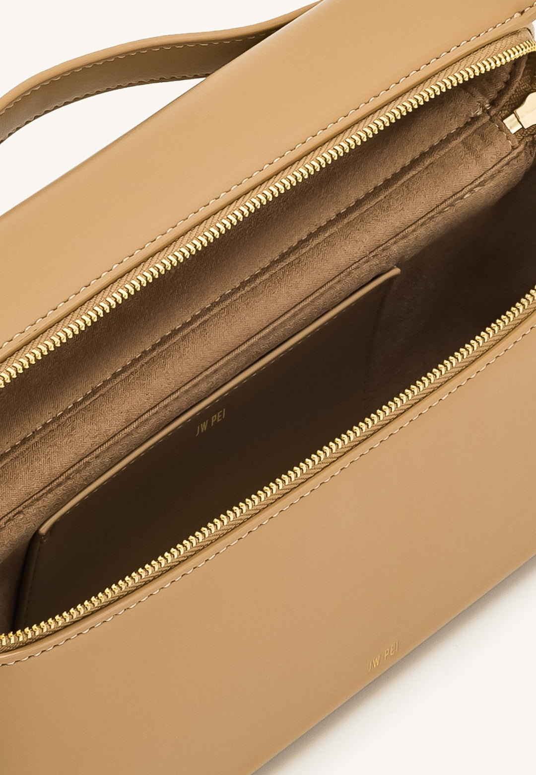 Intérieur du sac à main JW PEI Thea Almond beige, avec fermeture zippée dorée et logo JW PEI discret