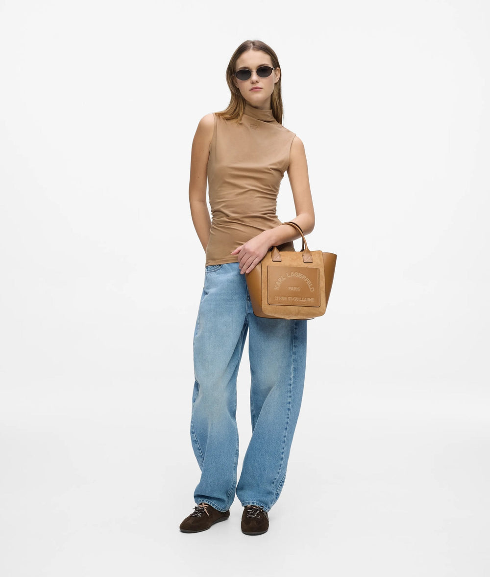 Karl Lagerfeld borsa Le Ballet marrone tenuta a mano, con un top beige senza maniche e jeans blu.