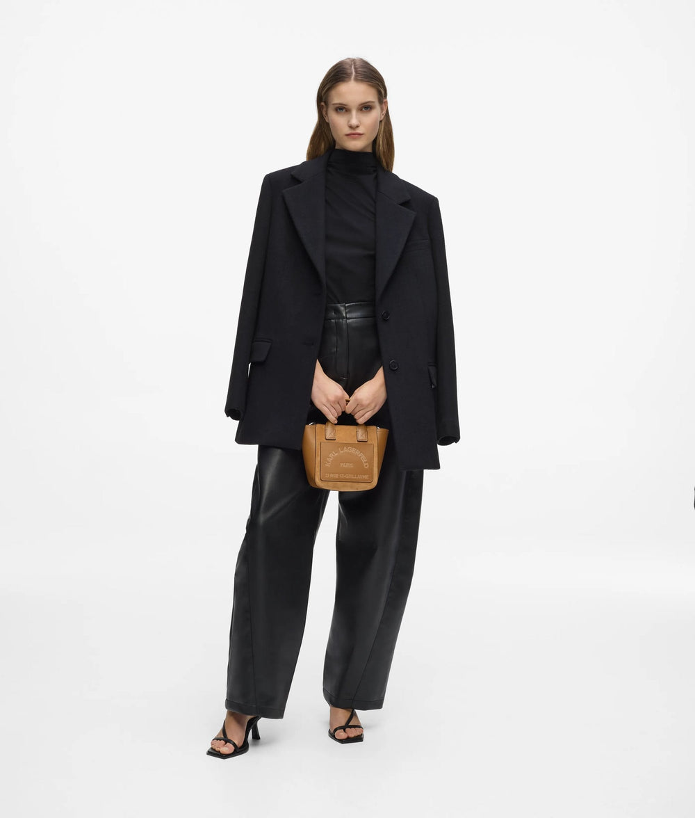 Karl Lagerfeld Tragetasche Le Ballet in Braun, in der Hand gehalten, mit schwarzem Mantel und weiter schwarzer Hose