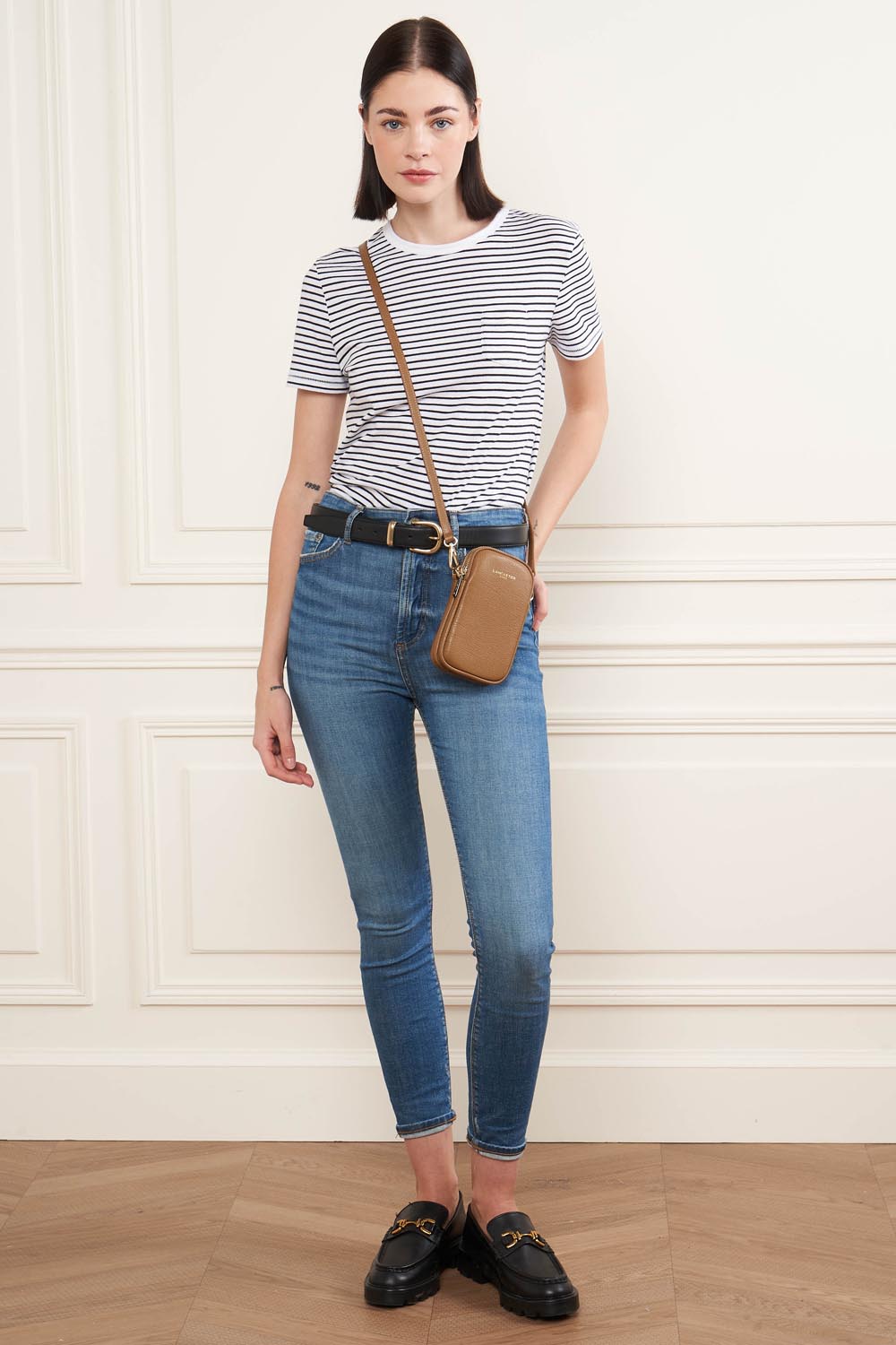 Lancaster Pochette smartphone Zippé Dune camel – T-shirt rayé et jean bleu pour la pochette Dune marron portée en bandoulière.