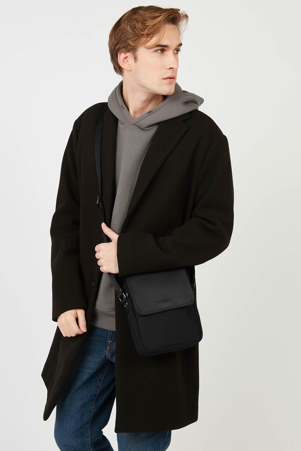Lancaster Mala Tiracolo Basic Sport Men's Preto – Em preto, a mala a tiracolo Basic Sport usa-se a tiracolo com um casaco preto e umas calças de ganga azuis.