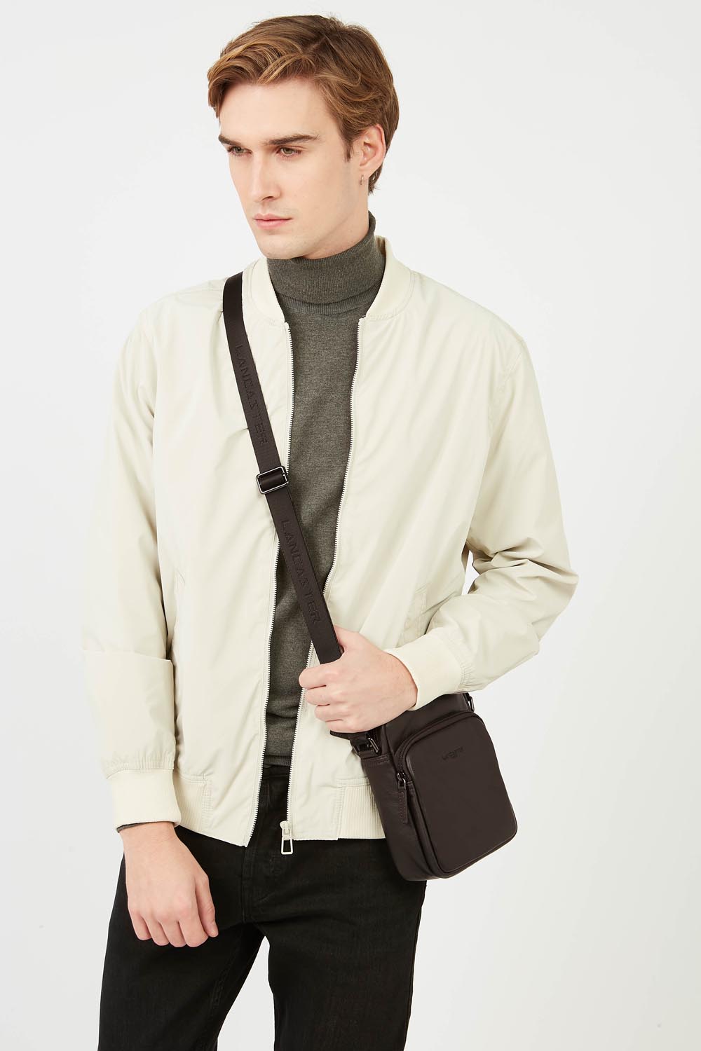 Lancaster Borsa a cartella Pelle Soft Vintage Blu/Cammello – La borsa a tracolla Soft Vintage marrone si abbina a una giacca color crema e pantaloni neri.