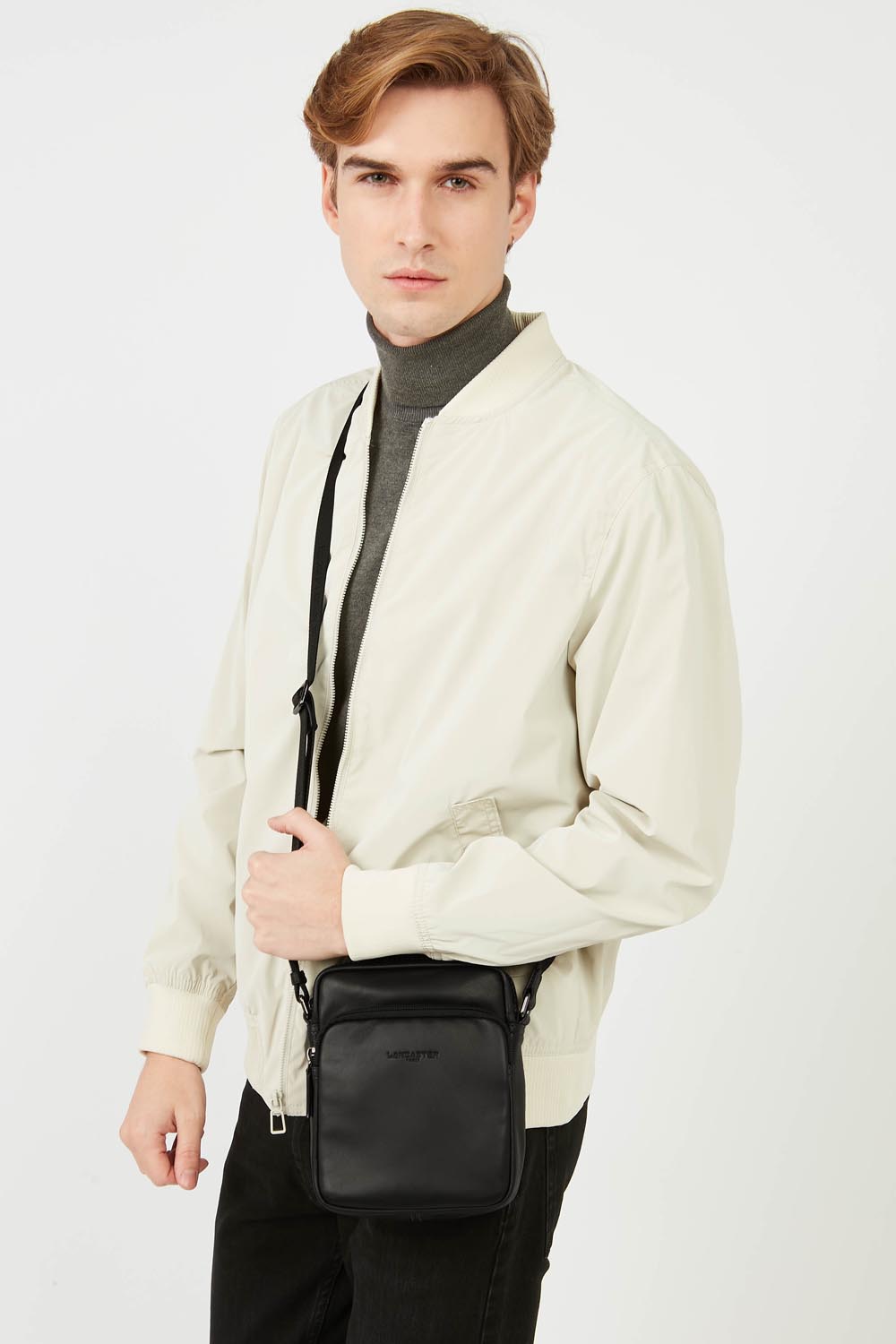Lancaster Borsa a cartella Pelle Soft Vintage Blu/Cammello – La borsa nera Soft Vintage si porta a tracolla e si abbina a una giacca bianca e a pantaloni neri.
