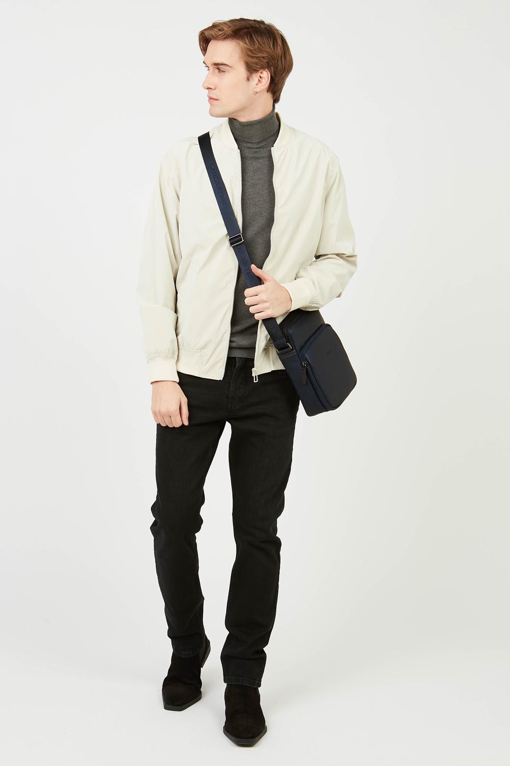 Lancaster besace Soft Vintage bleu foncé portée en bandoulière, avec une veste claire et un pantalon noir.