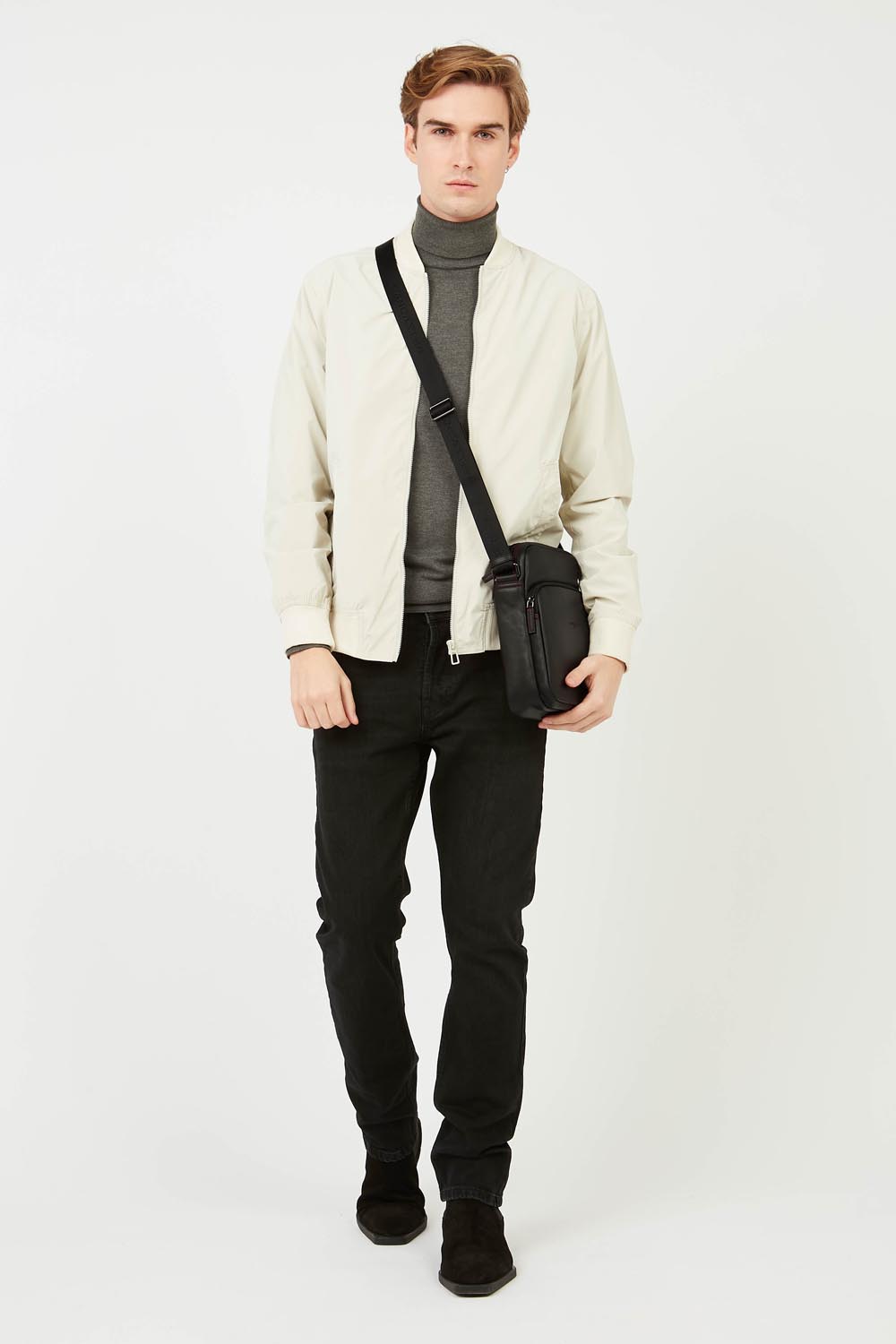 Lancaster besace Soft Vintage noire portée en bandoulière avec une tenue claire et sombre.