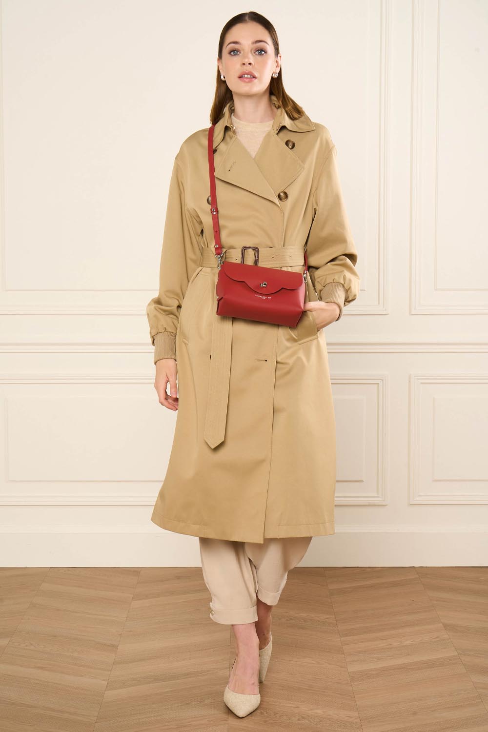 Lancaster Sac rabat PUR & ELEMENT CITY FLORE Noir/Champagne – Trench beige et pantalon clair pour le sac à rabat City Flore rouge porté en bandoulière.
