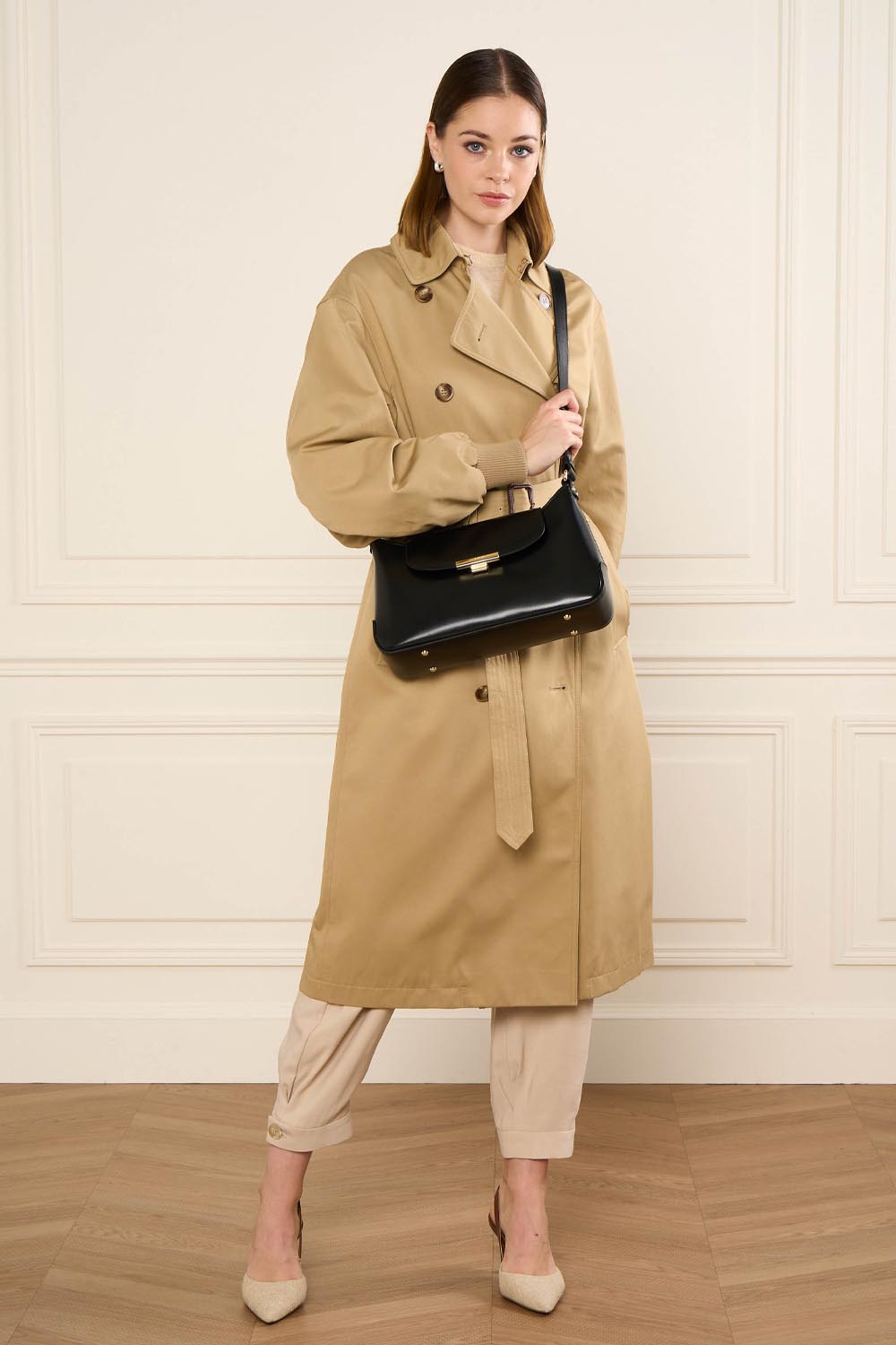 Lancaster Baguette tas Suave Evenly L Camel – Beige trenchcoat en lichte broek bij de baguette Suave Evenly over de schouder gedragen.