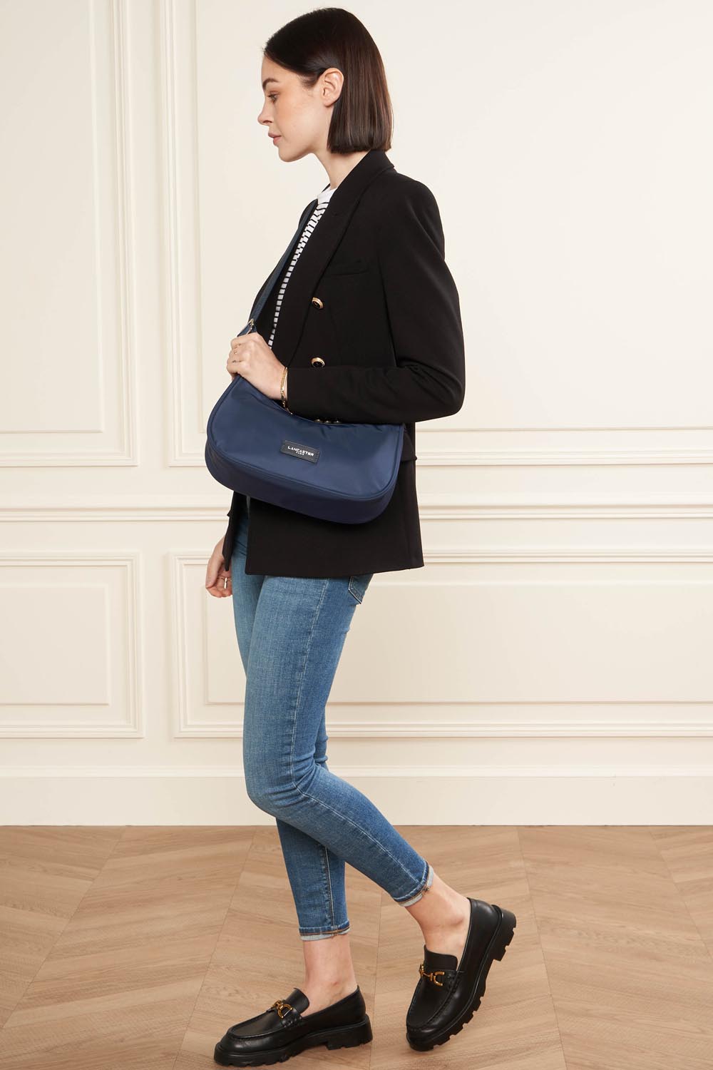 Lancaster Umhängetasche Basic Vita mit Reißverschluss – Die Umhängetasche Basic Vita wird zu einem schwarzen Blazer und einer blauen Jeans getragen.