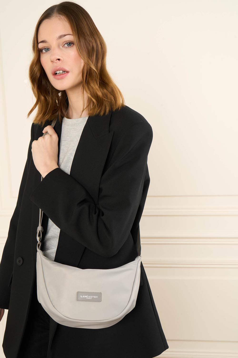 Sac banane Zippé Basic Vita Lancaster Gris Clair – Mat engem schwaarze Blazer an engem groe Top gëtt d’Bauchtäsch Basic Vita queesch iwwer de Kierper gedroen.