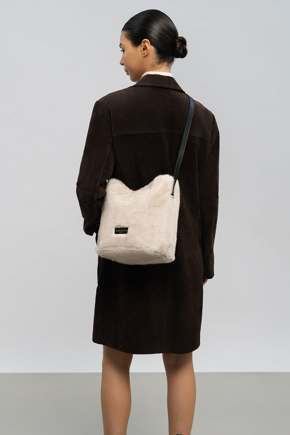 Lancaster Bucket Bag Magnetic Moumoute Ecru - Black – With a brown coat and a matching skirt, the beige Moumoute bucket bag is worn crossbody.