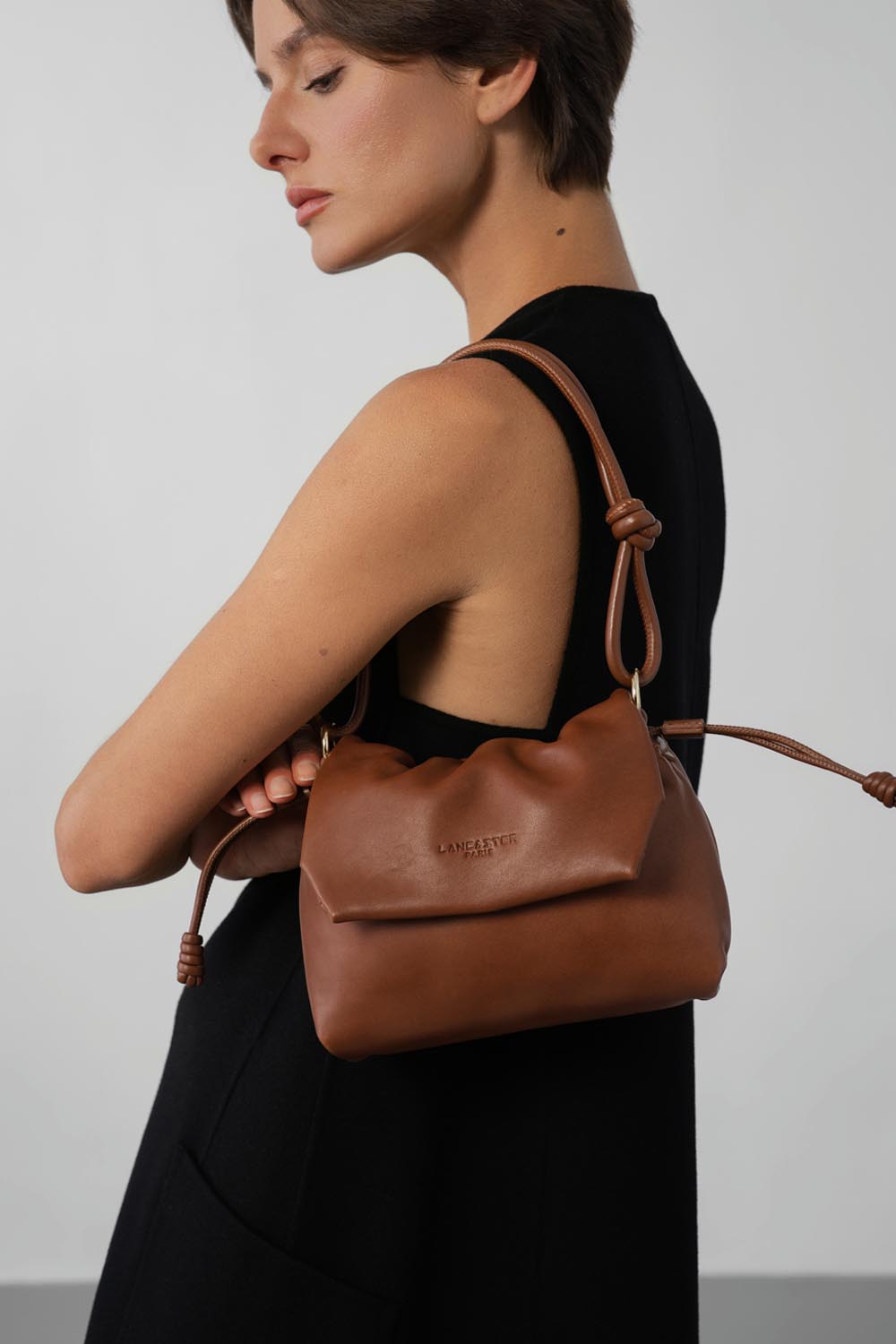Lancaster Borsa a tracolla con patta magnetica S Lush Nero – La borsa a spalla Lush marrone completa un outfit nero.