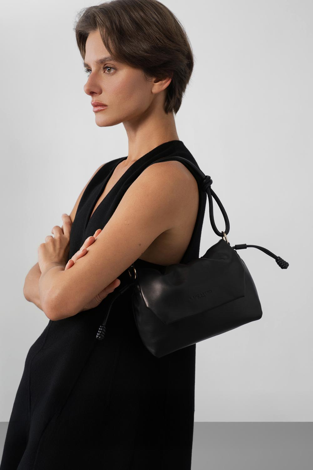 Lancaster Borsa a tracolla con patta magnetica S Lush Nero – Sulla spalla, la borsa a tracolla Lush nera si abbina a un abito nero senza maniche e a un top nero.