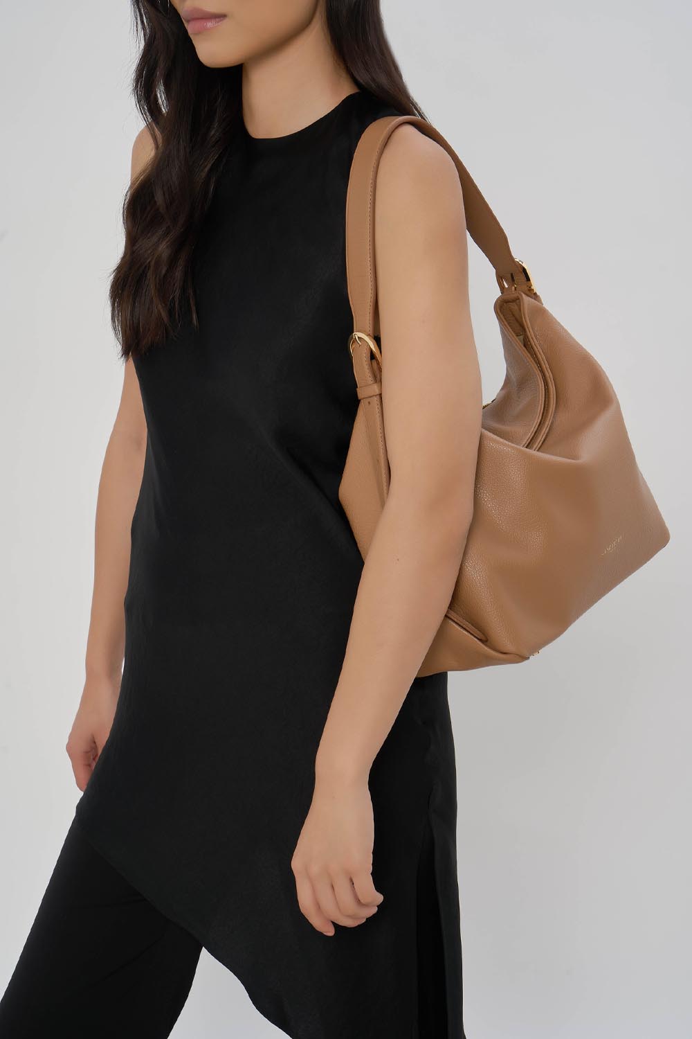 Lancaster Borsa a secchiello con zip Dune Blu – La borsa a secchiello Dune marrone si porta a spalla con un abito nero e pantaloni neri.