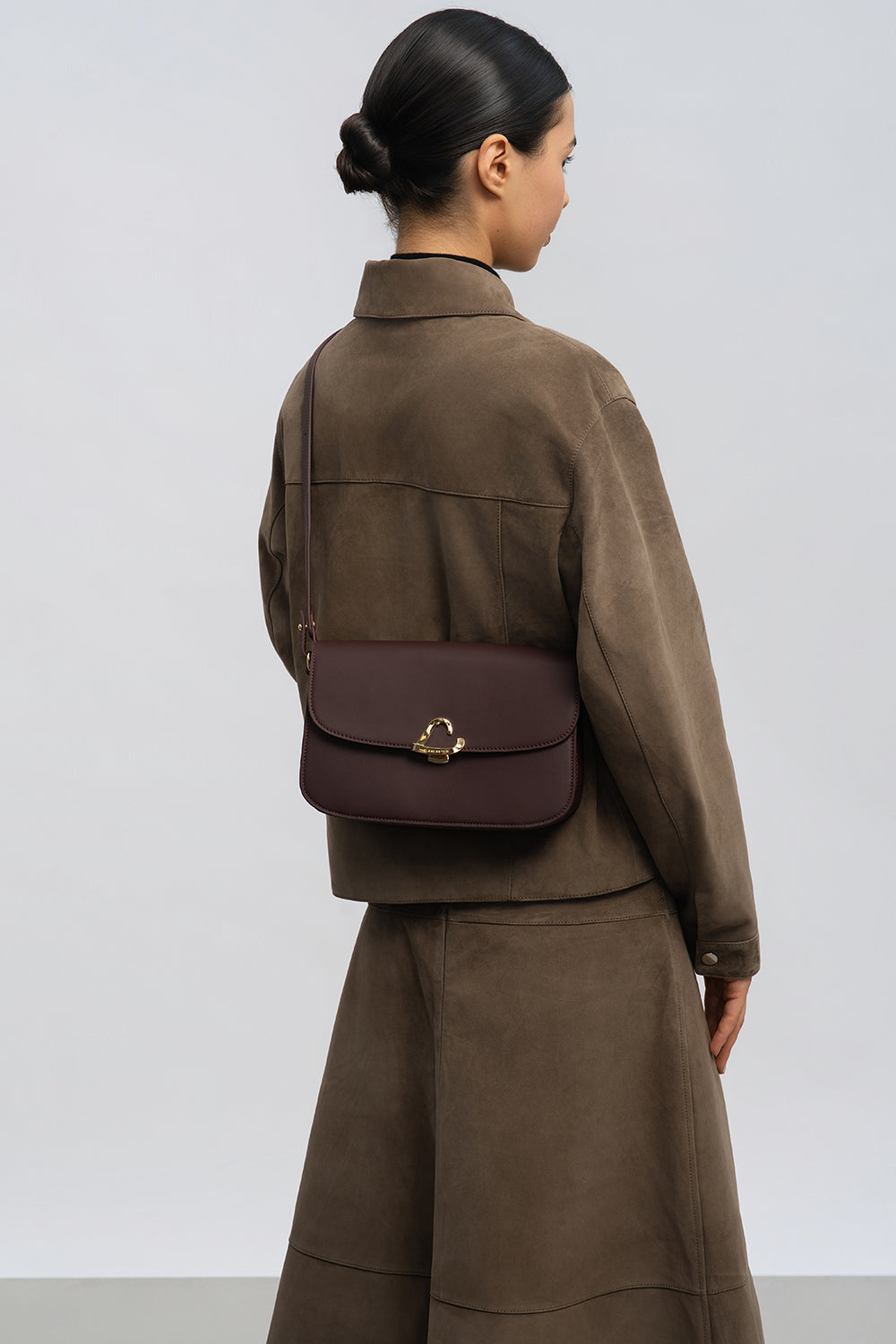 Lancaster Sac trotteur à rabat aimanté Paris Philos Noir – Den Trotteur Paris Philos gëtt crossbody mat enger bronger Jackett an engem laange Rock gedroen.