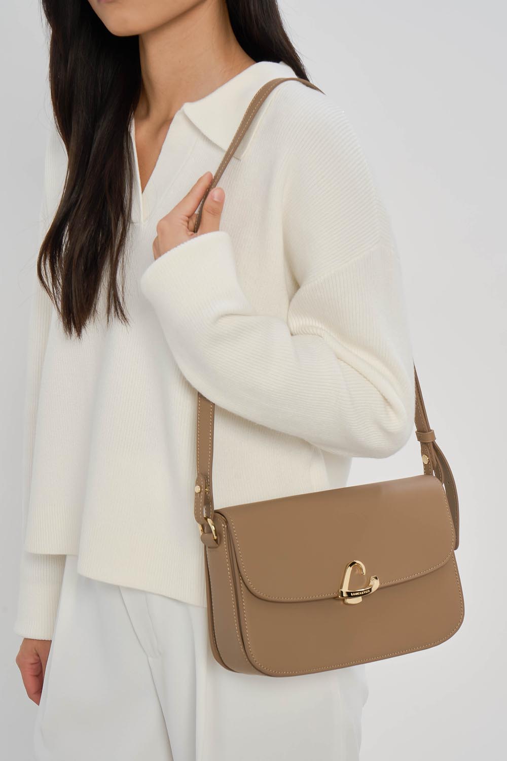 Lancaster Sac trotteur à rabat aimanté Paris Philos Noir – Iwwer der Schëller gedroen, passt den beige Paris Philos Trotteur zu engem wäissen Top an enger wäisser Box.