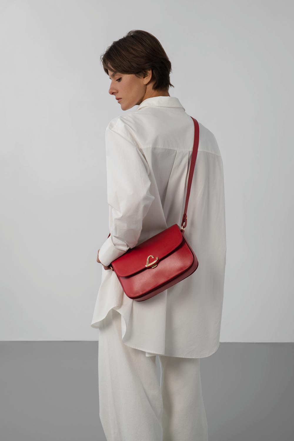 Lancaster Sac trotteur à rabat aimanté Paris Philos Noir – A Rout ass de Paris Philos Trotteur als Crossbody-Täsch zesumme mat engem wäissen Hiem an enger wäisser Box gedroen.