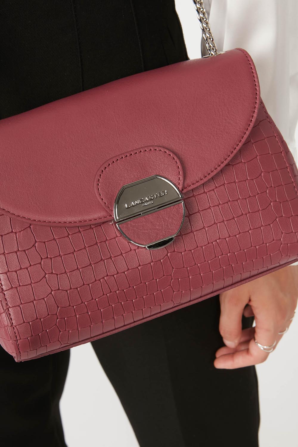 Lancaster Pia Camel Flap Crossbody Bag – Over the shoulder, the Pia satchel completes an all-black outfit, with a silver-tone chain visible.