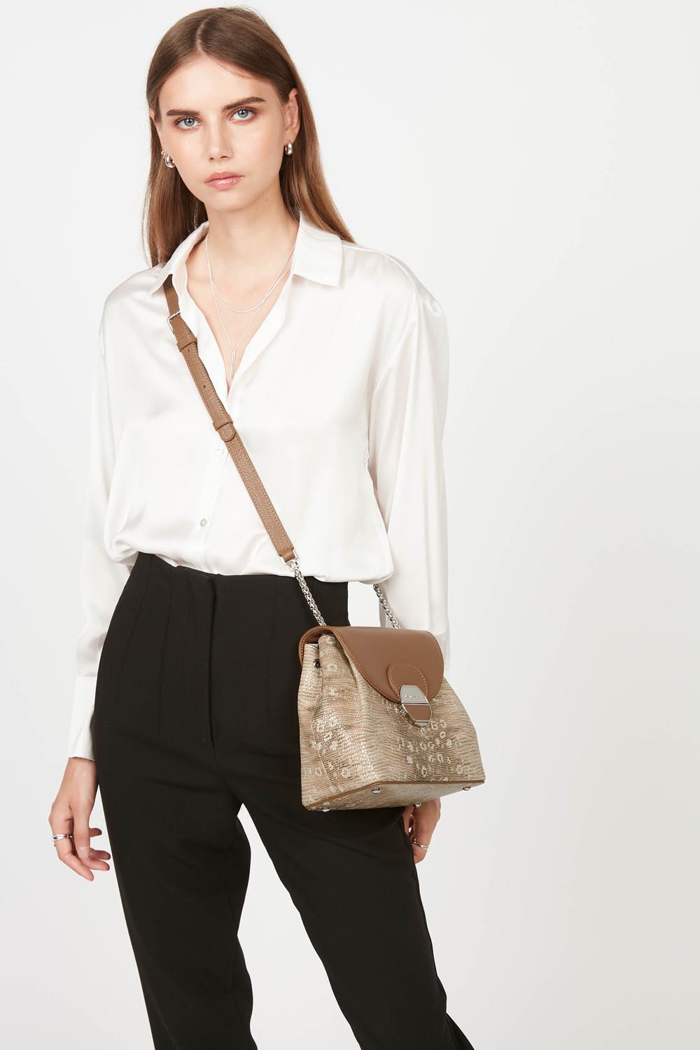 Lancaster Borsa a tracolla con patta e chiusura Pia Camel – La borsa Pia si porta a tracolla con una camicia bianca e pantaloni neri.