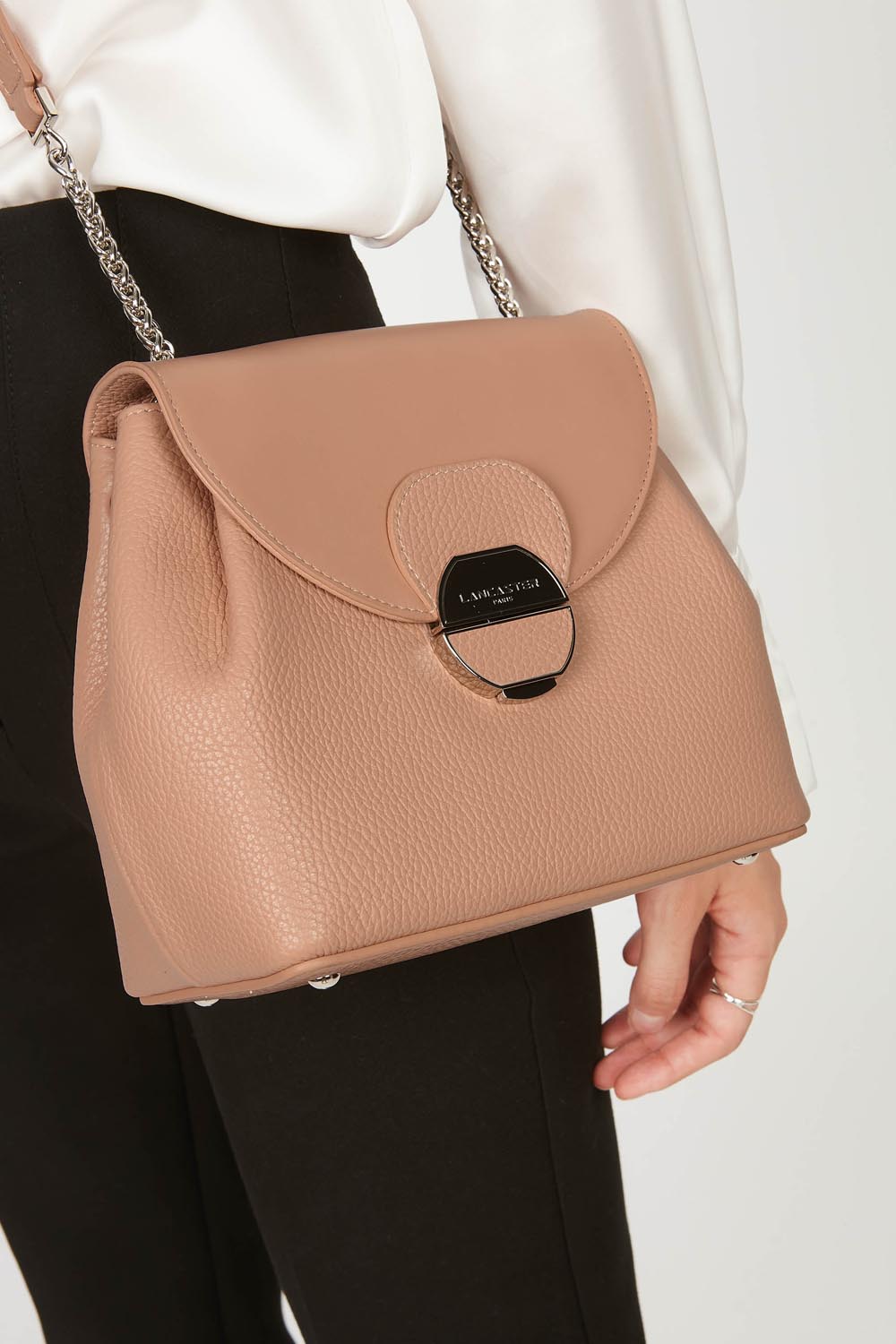 Lancaster Borsa a tracolla con patta e chiusura Pia Camel – La borsa Pia a tracolla si abbina a una camicia bianca e a pantaloni neri.