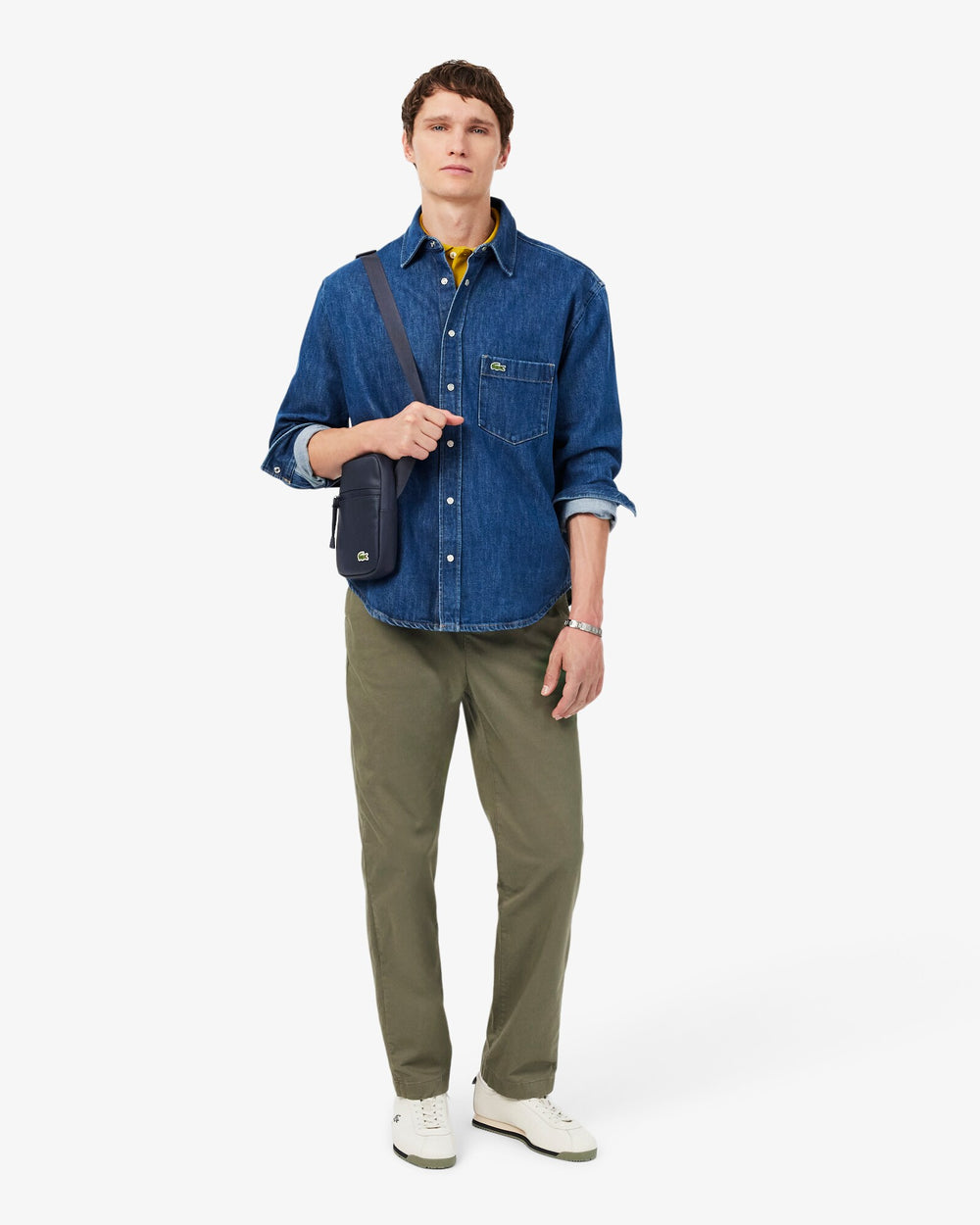 Lacoste tracolla Lcst blu indossata a bandoliera con camicia di jeans e pantaloni kaki.